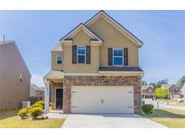 Charming two-story home showcasing a stone facade, attached garage, and a well-maintained front yard in a suburban neighborhood at 6399 Woodwell Dr, Union City, GA 30291