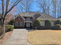Charming brick home with a landscaped front yard and a long, curved driveway leading to the entrance at 1140 Matheson Way, Alpharetta, GA 30022