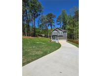 New two-story home featuring a 2-car garage and inviting front porch, all nestled on a well-manicured lawn at 113 Miller Rd, Stockbridge, GA 30281