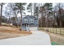 Two-story home featuring a driveway, garage, front porch, and wooden fence at 113 Miller Rd, Stockbridge, GA 30281