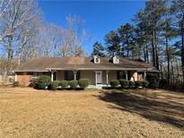 Charming single-story home with a covered front porch and well-manicured landscaping at 440 Ward Rd, Ellenwood, GA 30294