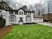 Charming two-story home boasts a freshly manicured lawn and a welcoming front entrance at 445 Bellflower Ct, Roswell, GA 30076