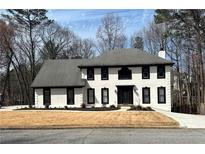 Charming two-story home features a classic white exterior with dark trim and a well-manicured lawn at 4960 Trevino Cir, Duluth, GA 30096