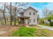 Charming two-story home with a front porch, driveway, and natural landscaping, perfect for suburban living at 202 Nathan Sw Rd, Atlanta, GA 30331