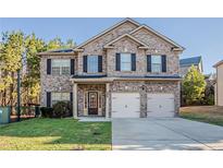 Charming two-story brick home with a well-manicured lawn and a two-car garage at 2154 Dodson Woods Dr, Fairburn, GA 30213