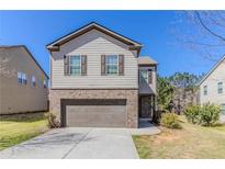 Charming two-story home with a brick and siding exterior and an attached two-car garage at 811 Lake Chase, Fairburn, GA 30213