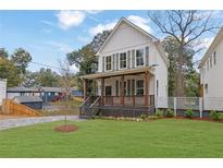 Charming two-story home with a landscaped yard, covered porch, and a paved driveway at 826 Gaston Street Sw, Atlanta, GA 30310