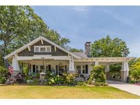 Charming bungalow featuring a landscaped yard, inviting front porch and convenient covered carport at 1000 Nw Main St, Conyers, GA 30012