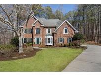 Beautiful brick two-story home with manicured lawn and mature landscaping at 655 Amberton Close, Suwanee, GA 30024