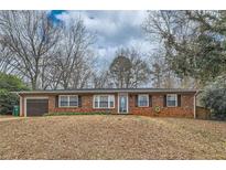 Charming brick home featuring a well-maintained lawn and a single-car attached garage at 2248 Greenway Drive, Decatur, GA 30035
