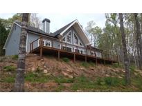 Charming home featuring a spacious deck, ideal for outdoor entertaining in a peaceful wooded setting at 8155 Stone Hill Rd, Cumming, GA 30028