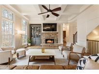 Bright living room features a stone fireplace, coffered ceilings, and hardwood floors at 2660 Burnt Hickory Dr, Cumming, GA 30028