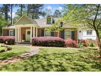 Charming brick home featuring a well-manicured lawn, colorful landscaping, and a welcoming front entrance at 1265 Oldfield Rd, Decatur, GA 30030