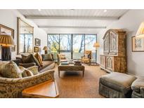 Cozy living room with a large window, patterned rug, a large antique cabinet, and comfortable seating at 2575 Peachtree Ne Rd # 8D, Atlanta, GA 30305