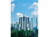 Modern high-rise building with a beautiful blue sky and green trees in the foreground at 3481 Lakeside Ne Dr # 2303, Atlanta, GA 30326
