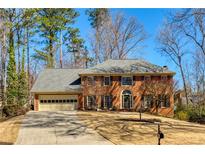 Traditional brick home with manicured lawn, attached garage, and mature trees, offers classic curb appeal at 3735 Borning Ct, Alpharetta, GA 30022