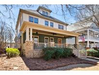 Charming two-story home featuring a welcoming front porch with stone accents and a manicured lawn at 1564 Spring Se St, Smyrna, GA 30080