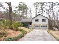 Charming two-story home featuring a two-car garage and a well-maintained front yard with mature trees at 326 Rockland Way, Lawrenceville, GA 30046
