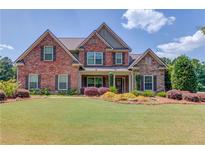 Beautiful brick home with manicured lawn and colorful landscaping in a desirable neighborhood at 1433 Henderson Ridge Ln, Loganville, GA 30052