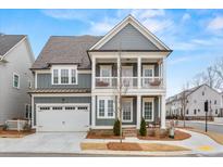 Charming two-story home with a welcoming front porch, gray siding and a two car garage in a suburban neighborhood at 800 Castile Ln, Woodstock, GA 30188