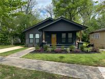 Charming home featuring a well-manicured lawn, fresh landscaping, and a welcoming yellow front door at 3028 E Point St, Atlanta, GA 30344