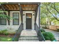 Inviting brick home featuring a dark front door, black railings and stylish exterior lighting at 18 Peachtree Ne Ave # 1, Atlanta, GA 30305