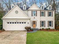 Charming two-story home with a well-manicured lawn, two-car garage and symmetrical shuttered windows at 6500 Maid Marion Close, Alpharetta, GA 30005