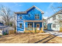 Charming two-story home features a light blue facade, a welcoming front porch, and manicured landscaping at 1092 Wedgewood Nw Dr, Atlanta, GA 30318