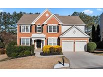 Charming two-story brick home featuring a manicured front yard and attached two-car garage at 3321 Spindletop Nw Dr, Kennesaw, GA 30144