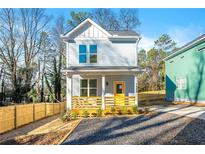 Charming two-story home with light blue siding, yellow front door, and a wooden porch at 1088 Wedgewood Nw Dr, Atlanta, GA 30318