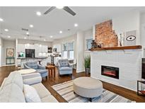 Open concept living room boasts a brick fireplace, hardwood floors, and plenty of natural light at 942 Byron Sw Dr, Atlanta, GA 30310