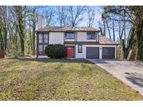 Two-story home with a two-car garage and a landscaped front yard at 1628 Links Overlook, Stone Mountain, GA 30088
