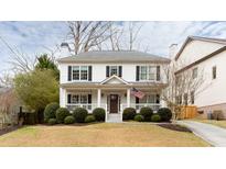 Charming two-story home with a covered front porch, well-manicured lawn, and mature landscaping at 2800 Georgian W Dr, Brookhaven, GA 30341