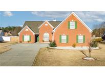 Charming single-story brick home featuring a well-maintained yard and inviting green shutters at 502 Stoneland Pl, Lawrenceville, GA 30046