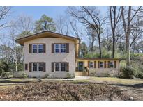 Charming brick home with wood shutters and a well-maintained front yard with mature trees at 3597 Embry Cir, Atlanta, GA 30341
