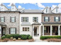 Charming townhome with brick and painted exteriors, shuttered windows, and manicured landscaping at 1986 Forte Ln, Alpharetta, GA 30009