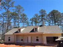 New home with dormer windows and attached garage, set against a backdrop of tall trees at 8141 Hickory Dr, Covington, GA 30014