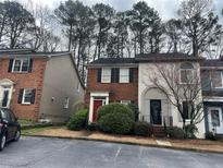Charming townhouse featuring a brick facade, red door, and front yard landscaping at 3998 Elm St, Atlanta, GA 30341