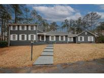 Charming two-story home with a landscaped yard, walkway, and gray siding and white shutters at 4995 Greentree Trl, College Park, GA 30349