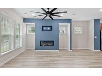 Bright living room with modern fireplace, a ceiling fan, and large windows offering plenty of natural light at 1570 Halbrook Pl, Marietta, GA 30008
