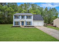 Charming two-story home with blue shutters, a well-manicured lawn, and an attached two-car garage at 4975 Rockstone Way, Acworth, GA 30101