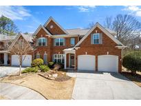 Charming brick home featuring a two-car garage, manicured lawn and traditional architectural details at 2330 Ventana Xing # 10, Marietta, GA 30062