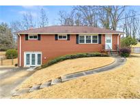 Charming brick home featuring a well-maintained lawn, driveway and manicured landscape at 3406 Woodview Se Dr, Smyrna, GA 30082