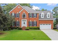 Charming two-story brick home with a manicured front lawn and attached two-car garage at 1274 Creek Laurel Dr, Lawrenceville, GA 30043