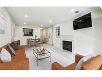 Inviting living room with a fireplace, view of kitchen, and modern furnishings offers a cozy atmosphere at 24308 Plantation Ne Dr, Atlanta, GA 30324