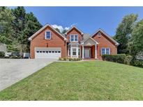 Charming two-story brick home with a well-manicured lawn and attached two-car garage at 1665 Windsong Park Dr, Dacula, GA 30019