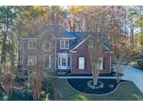 Traditional brick home featuring mature landscaping and a well-manicured lawn at 2001 Towne Lake W Hls, Woodstock, GA 30189