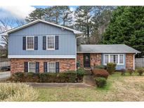 Charming two-story home with brick and blue siding, complemented by well-maintained landscaping at 607 Cascade Sw Dr, Lilburn, GA 30047