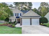 Charming two-story home featuring a well-maintained lawn, attached two-car garage, and inviting front entrance at 1171 Pine Acre Dr, Sugar Hill, GA 30518