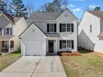 Charming two-story home features a white brick facade, black shutters, and attached garage at 900 Melrose Park Pl, Lawrenceville, GA 30044